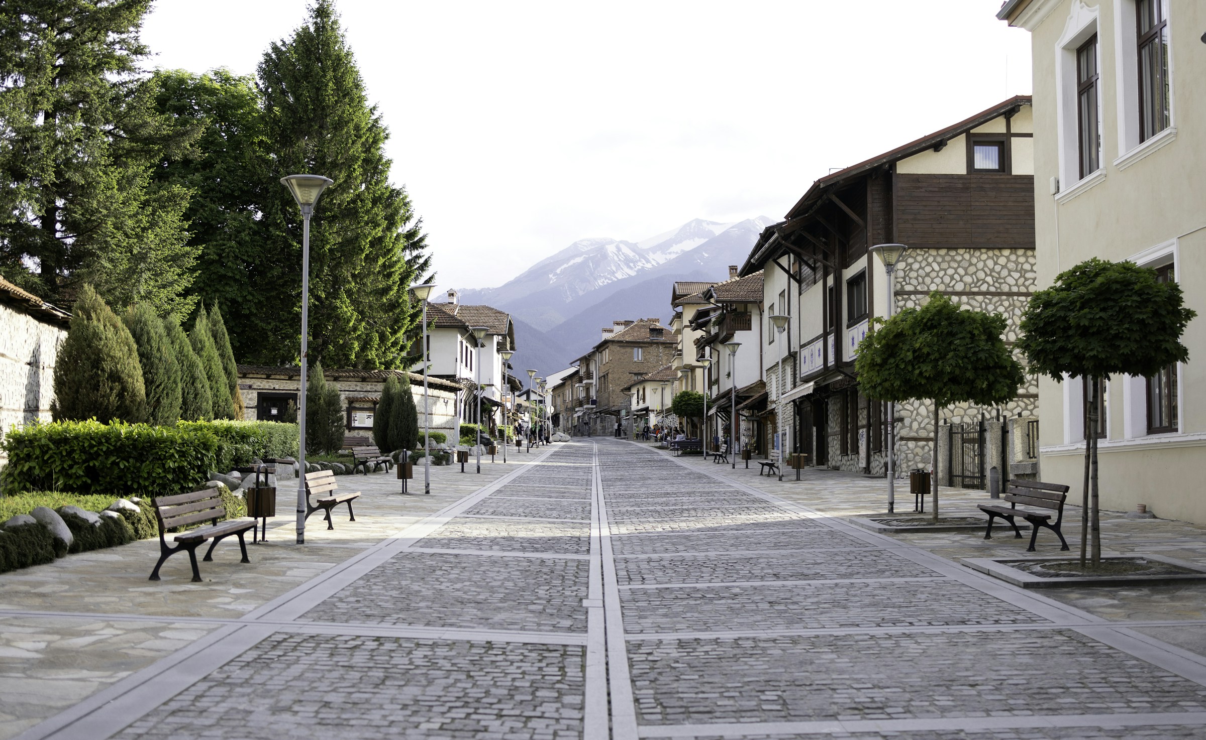 Cobblestone street in Bansko town centre with Pirin behind it